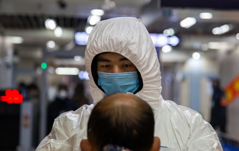 BEIJING, CHINA - JANUARY 26: A health worker checks the temperature of a man entering the subway on January 26, 2020 in Beijing, China. The number of cases of coronavirus rose to 1,975 in mainland China on Sunday. Authorities tightened restrictions on travel and tourism this weekend after putting Wuhan, the capital of Hubei province, under quarantine on Thursday. The spread of the virus corresponds with the first days of the Spring Festival, which is one of the biggest domestic travel weeks of the year in China. Popular tourism landmarks in Beijing including the Forbidden City, Badaling Great Wall, and The Palace Museum were closed to the public starting Saturday. The Beijing Municipal Education Commission announced it will delay reopening schools from kindergarten to university. The death toll on Sunday rose to 56. The majority of fatalities are in Wuhan where the first cases of the virus were reported last month. (Photo by Betsy Joles/Getty Images)