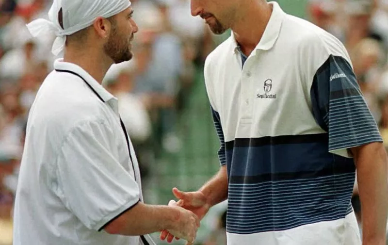 Andre Agassi of the US (L) shakes hands with Goran Ivanisevic of Croatia after Ivanisevic was forced to retire in the fourth game of the first set of the finals of the men's singles at the Lipton Tennis Championships in Key Biscayne, Florida 31 March. Ivanisevic retired due to muscle spasms in his neck and shoulder.   AFP PHOTO/Chris BERNACCHI / AFP PHOTO / CHRIS BERNACCHI