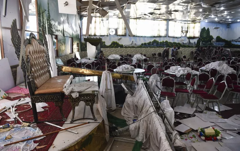 Afghan men investigate in a wedding hall after a deadly bomb blast in Kabul on August 18, 2019. - More than 60 people were killed and scores wounded in an explosion targeting a wedding in the Afghan capital, authorities said on August 18, the deadliest attack in Kabul in recent months. (Photo by Wakil KOHSAR / AFP)