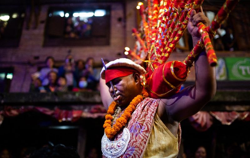 Birendra Bhakta Shrestha carrying oil lamp walks around the city after piercing his tongue by a needle on the occasion of Indra Jatra at Madhyapur Thimi, Nepal on Saturday, September 10, 2022. (Photo by Rojan Shrestha/NurPhoto) (Photo by Rojan Shrestha / NurPhoto / NurPhoto via AFP)