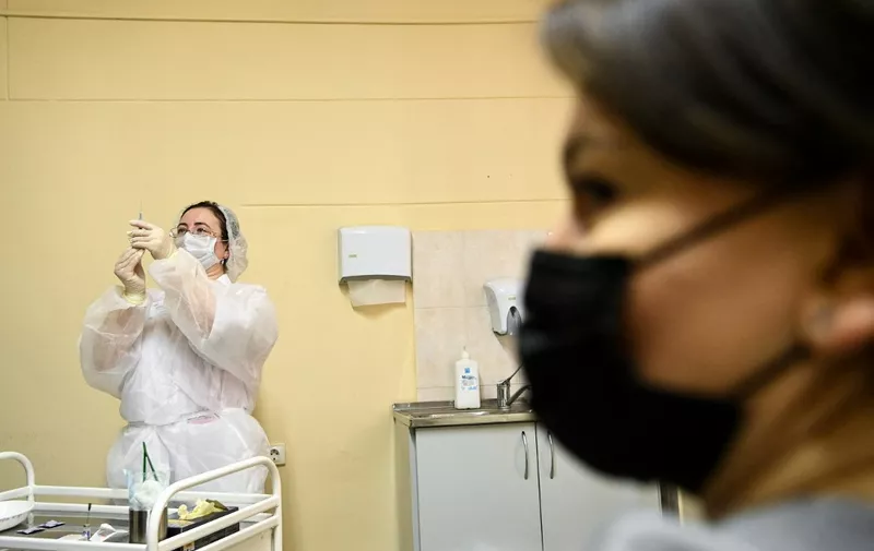 A nurse wearing a face mask proceeds to a vaccination against the coronavirus disease (COVID-19) by Sputnik V (Gam-COVID-Vac) vaccine at a clinic in Moscow on December 5, 2020, amid the ongoing coronavirus disease pandemic. - Russian President has told authorities to begin "large-scale" vaccinations among at-risk populations. The drugs should be made generally available to the Russian public in early 2021. (Photo by Kirill KUDRYAVTSEV / AFP)