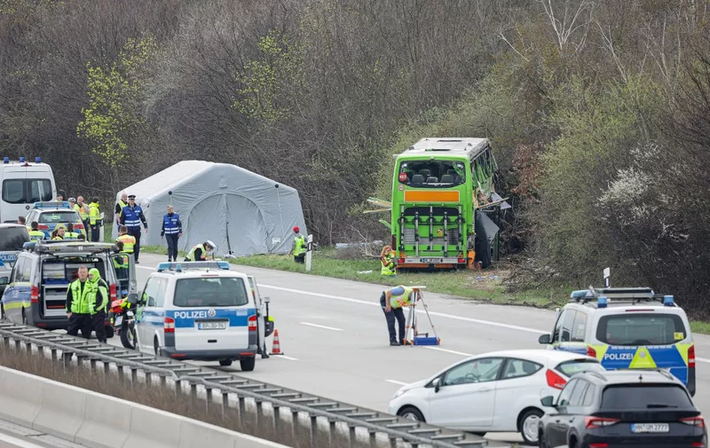 Police officers are seen at the scene of a bus accident on the A9 highway, where at least five people were killed, on March 27, 2024 in Schkeuditz, near Leipzig, eastern Germany. (Photo by Jens Schlueter / AFP)