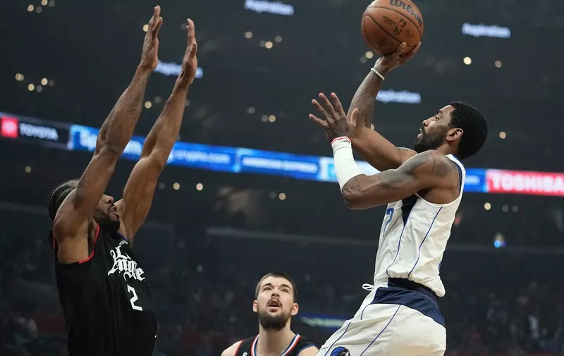 Dallas Mavericks guard Kyrie Irving, right, shoots as Los Angeles Clippers forward Kawhi Leonard, left, defends along with center Ivica Zubac during the first half of an NBA basketball game Wednesday, Feb. 8, 2023, in Los Angeles. (AP Photo/Mark J. Terrill)