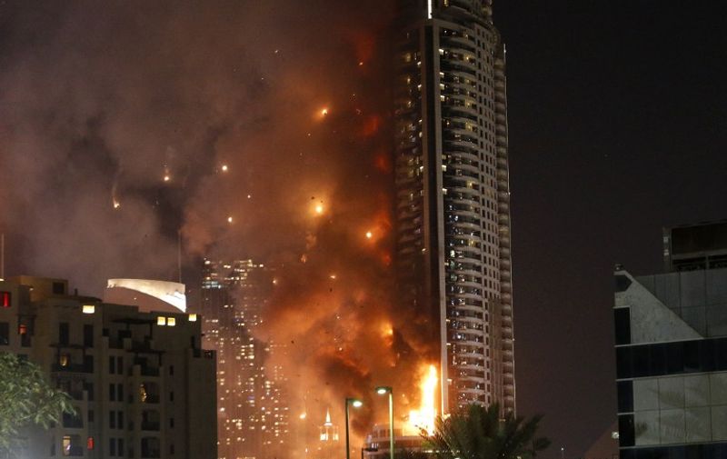 Flames rip through the Address Downtown hotel after it was hit by a massive fire, near the world's tallest tower, Burj Khalifa, in Dubai, on December 31, 2015. People were gathering to watch New Year's Eve celebrations when the hotel caught on fire, with the cause of the blaze still unknown according to the emirate's police chief. AFP PHOTO / KARIM SAHIB / AFP / KARIM SAHIB