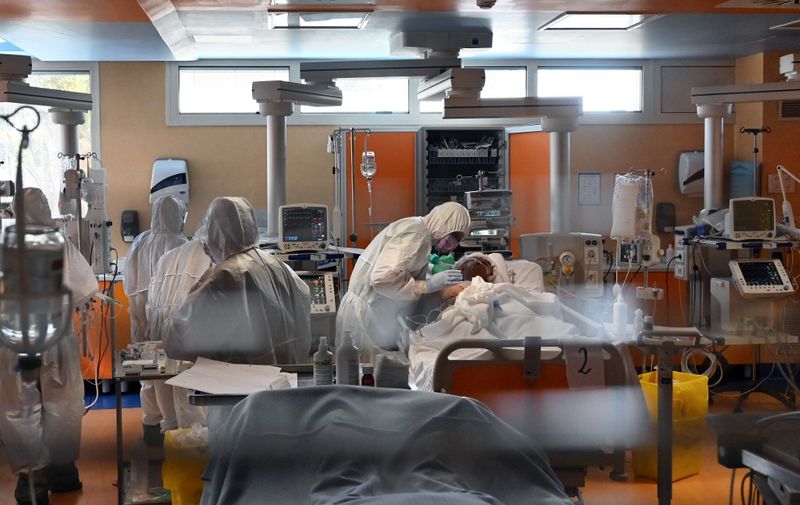A medical worker in protective gear (C) tends to a patient on March 24, 2020 at the new COVID 3 level intensive care unit for coronavirus COVID-19 cases at the Casal Palocco hospital near Rome, during the country's lockdown aimed at stopping the spread of the COVID-19 (new coronavirus) pandemic. (Photo by Alberto PIZZOLI / AFP)