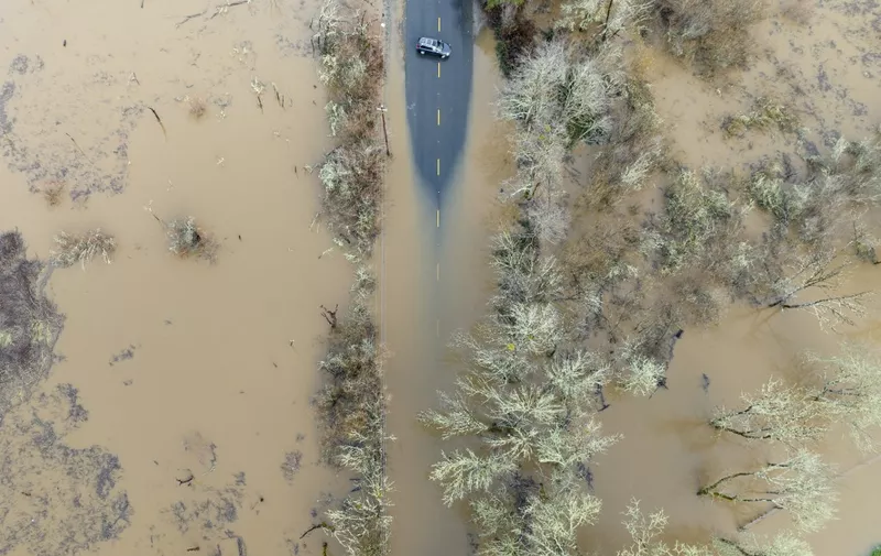 A vehicle turns around on a flooded road in Sebastopol, California, on January 05, 2023. - Excessive rain, heavy snow and landslides are expected to wallop California through Thursday as a series of winter storms rip across the western US coast, prompting Governor Gavin Newsom to declare a state of emergency. (Photo by JOSH EDELSON / AFP)