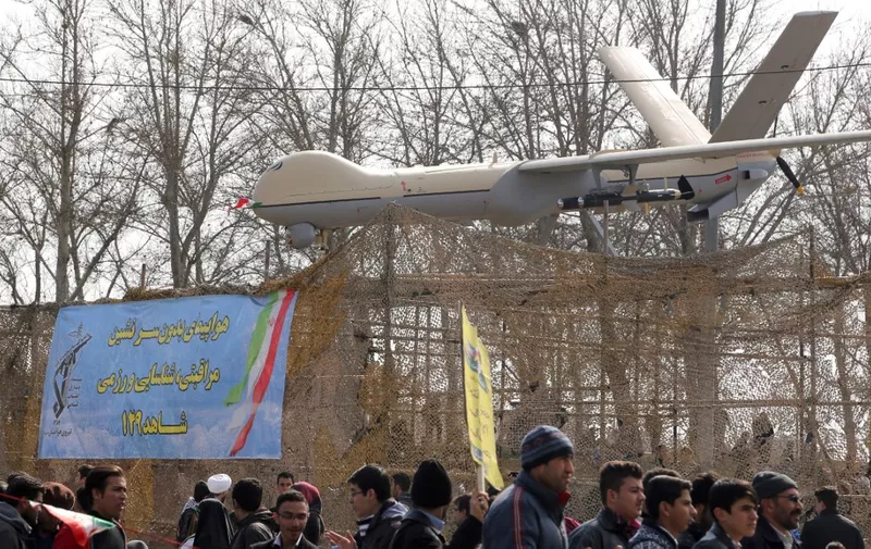 Iranians walk past Iran's Shahed 129 drone during celebrations in Tehran to mark the 37th anniversary of the Islamic revolution on February 11, 2016. Iranians waved "Death to America" banners and took selfies with a ballistic missile as they marked 37 years since the Islamic revolution, weeks after Iran finalised a nuclear deal with world powers. (Photo by ATTA KENARE / AFP)