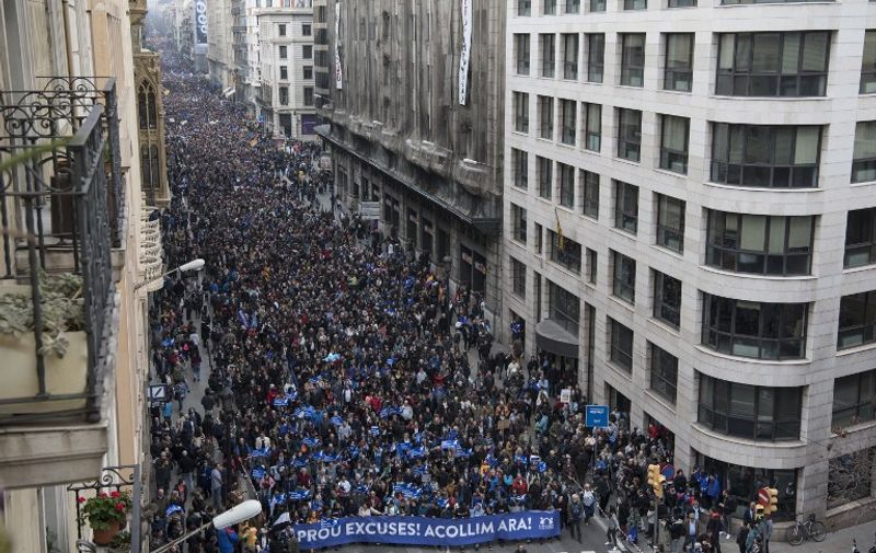 Thousands of people walk in a street of Barcelona during a demonstration demanding to welcome refugees on February 18, 2017. 
Some 160,000 people participated today in a demonstration in Barcelona to demand that Spain welcomes "right now" thousands of refugees as it had committed itself in 2015. / AFP PHOTO / Josep Lago