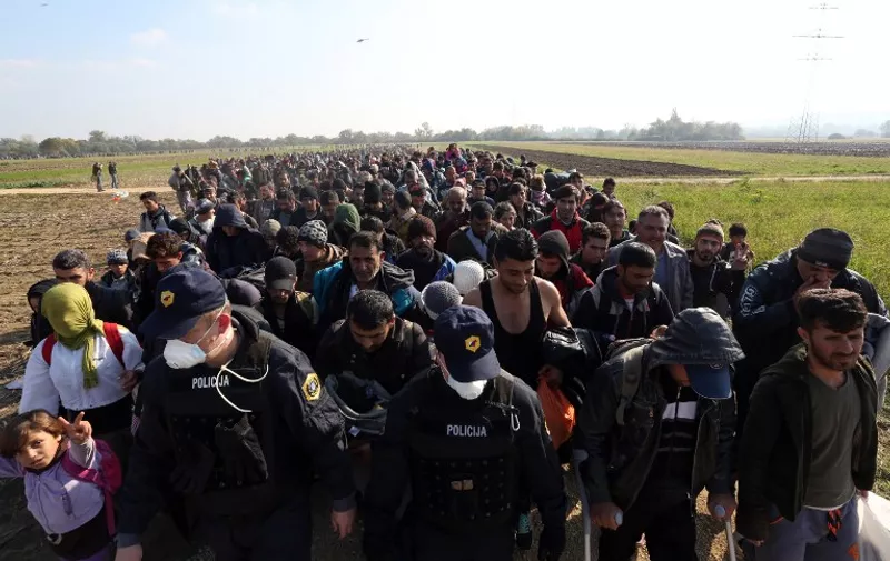 TOPSHOTS
Migrants and refugees, who spent the night outdoors, are escorted by Slovenian soldiers and police officers as they walk towards a refugee camp after crossing the Croatian-Slovenian border near Rigonce, Slovenia, on October 26, 2015. The European Union will "start falling apart" if it fails to take concrete action to tackle the migrant crisis within the next few weeks, Slovenian Prime Minister Miro Cerar warned on October 25.  AFP PHOTO STRINGER