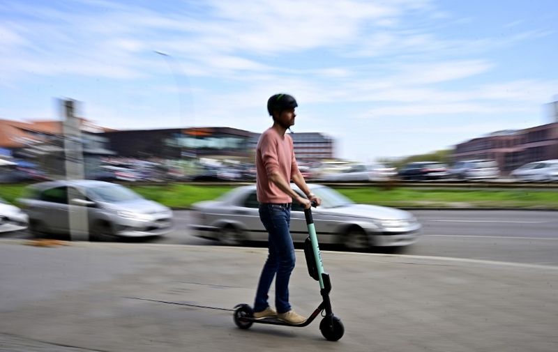 A man rides an E-Scooter of rental company Tier in Berlin on April 17, 2019. - German ministers agreed rules for using battery-powered scooters on the country's roads, paving the way for the two-wheeled craze to spread further across Europe. (Photo by Tobias SCHWARZ / AFP)