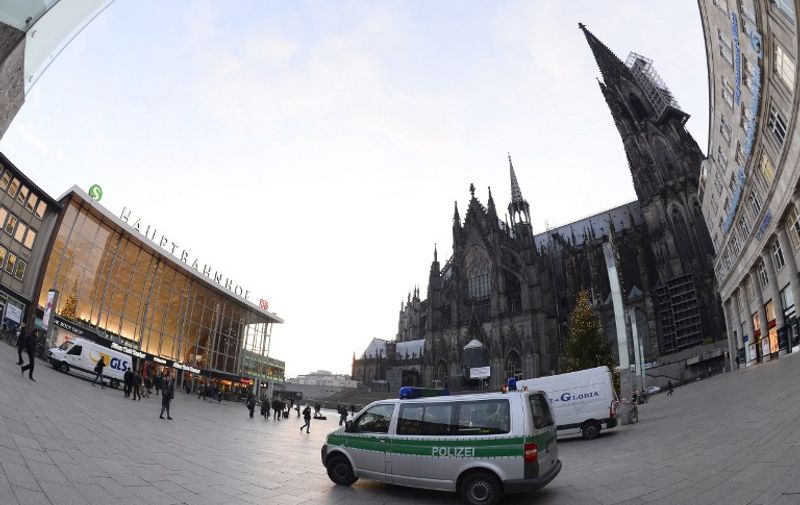 A police car is parked in front of Cologne's landmark, the Cologne Cathedral, near the main railway station, on January 7, 2016, where apparently coordinated sex attacks were perpetred during New Year's Eve.
Police in Cologne told AFP they have received more than 100 complaints by women reporting assaults ranging from groping to rapes, allegedly committed in a large crowd of revellers during year-end festivities outside the city's main train station and its famed Gothic cathedral. / AFP / Roberto Pfeil
