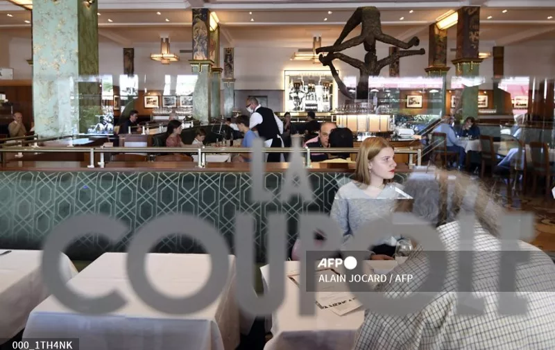People have lunch at the restaurant La Coupole in Paris, on June 15, 2020, as cafes and restaurants are allowed to serve customers inside, as well as on terraces, as part of the easing of lockdown measures taken to curb the spread of the COVID-19 pandemic, caused by the novel coronavirus. (Photo by ALAIN JOCARD / AFP)