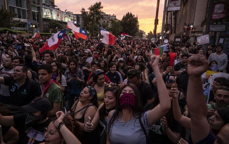 Demonstrators gather in Santiago, on October 25, 2019, a week after protests started. - Demonstrations against a hike in metro ticket prices in Chile's capital exploded into violence on October 18, unleashing widening protests over living costs and social inequality. (Photo by Pedro Ugarte / AFP)