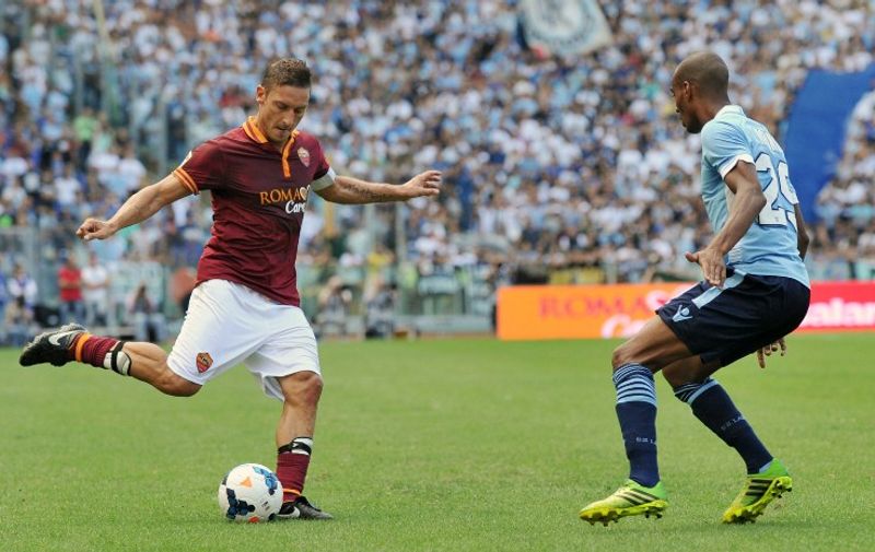 AS Roma's forward Francesco Totti (L) vies with Lazio's French defender Abdoulay Konko during the Italian Serie A football match between AS Roma and Lazio of Rome at the Olympic stadium on September 22, 2013  in Rome. 