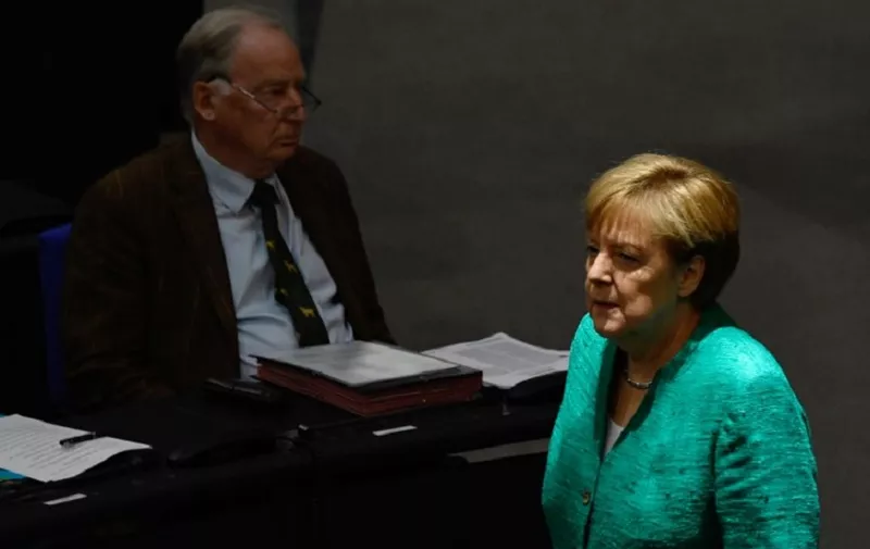 German Chancellor Angela Merkel walks past Alexander Gauland (L), parliamentary group co-leader of Germany's far-right Alternative for Germany (AfD), at the beginning of a session at the Bundestag (lower house of parliament) on June 28, 2018 in Berlin.
Merkel warned that the migration challenge could determine Europe's fate, hours ahead of a Brussels summit with EU leaders expected to clash over the way forward. / AFP PHOTO / John MACDOUGALL