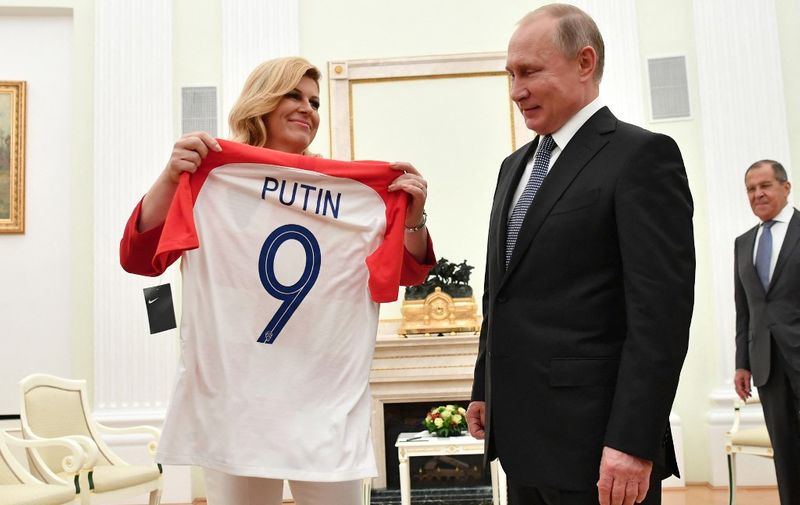 Croatian President Kolinda Grabar-Kitarovic (L) offers to Russian President Vladimir Putin a jersey of the Croatian national football team bearing the name Putin, ahead of the Russia 2018 World Cup final football match between France and Croatia, during their meeting at the Kremlin in Moscow on July 15, 2018. (Photo by Yuri KADOBNOV / POOL / AFP)