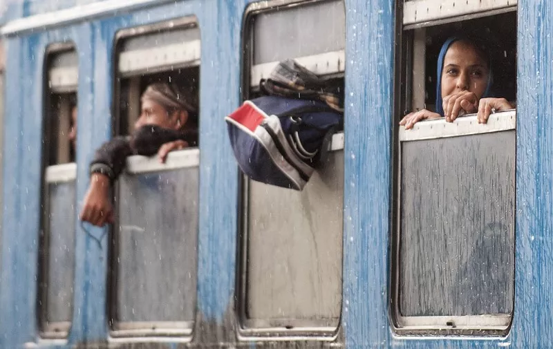 Migrants look out from a coach window at a train station in Veles, central Macedonia, on June 20, 2015, on their way North to the Serbian border. Macedonian lawmakers on Thursday amended the country's asylum law in a bid to better cope with the thousands of migrants who have been pouring in the Balkan country, heading towards the EU. AFP PHOTO / ROBERT ATANASOVSKI