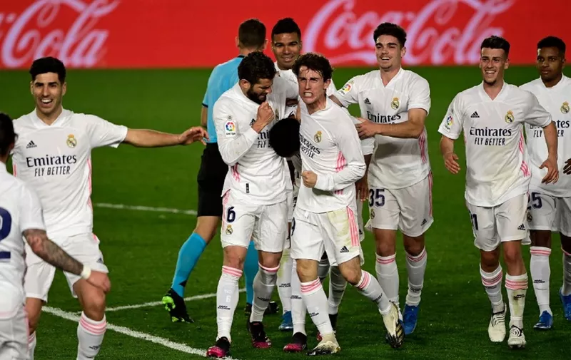 Real Madrid's Brazilian defender Eder Militao (C) celebrates with teammates after scoring during the Spanish League football match between Real Madrid and Osasuna at the Alfredo Di Stefano stadium in Valdebebas in the outskirts of Madrid on May 1, 2021. (Photo by JAVIER SORIANO / AFP)