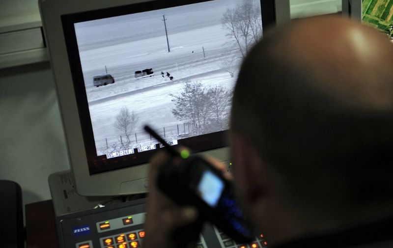 A Romanian police officer talks with operational team as he observes suspicious activities along the border on a thermal vision camera during a drill at the Sculeni border crossing point from Romania to the Republic of Moldova January 18, 2011. Romanian border police is tightening controls at the border with Moldova in order to fulfill requirements to enter the border-free Schengen zone in March 2011, but France and Germany have publicly opposed such a move. Bucharest insists that formerly Schengen enlargements were made only on the basis of technical criteria like the implementation of a secure border control system and warns against an "unfair change of the rules".  AFP PHOTO / DANIEL MIHAILESCU