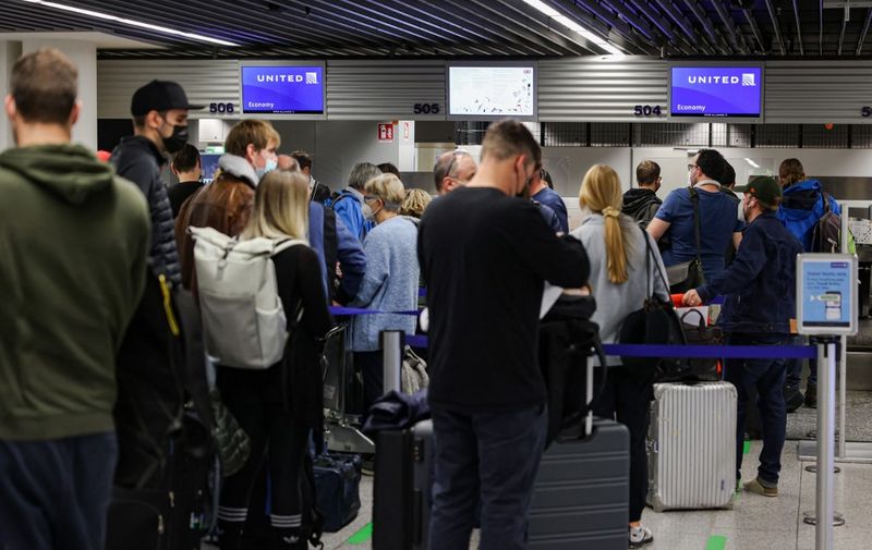 People wait in line to check in for flights to the United States at the airport in Frankfurt am Main, western Germany, on November 8, 2021 as the US has lifted its travel ban for vaccinated travelers. - The United States reopened its borders to foreign visitors fully vaccinated against Covid-19 after 20 months of travel restrictions, paving the way for eagerly anticipated reunions among family members and friends. The ban, imposed by then president Donald Trump in early 2020 and upheld by his successor Joe Biden, has been widely criticized and become emblematic of the upheavals caused by the pandemic. (Photo by Yann Schreiber / AFP)