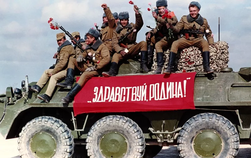 Soviet airborne regiments cross the Afghan border to USSR with a banner on the tank reading "Hello motherland", on February 6, 1989 in Termez, base of Soviet Union military operations in Afghanistan, during the Afghan Civil War, after Soviet withdrawal from Afghanistan. (Photo by Vitaly ARMAND / AFP)