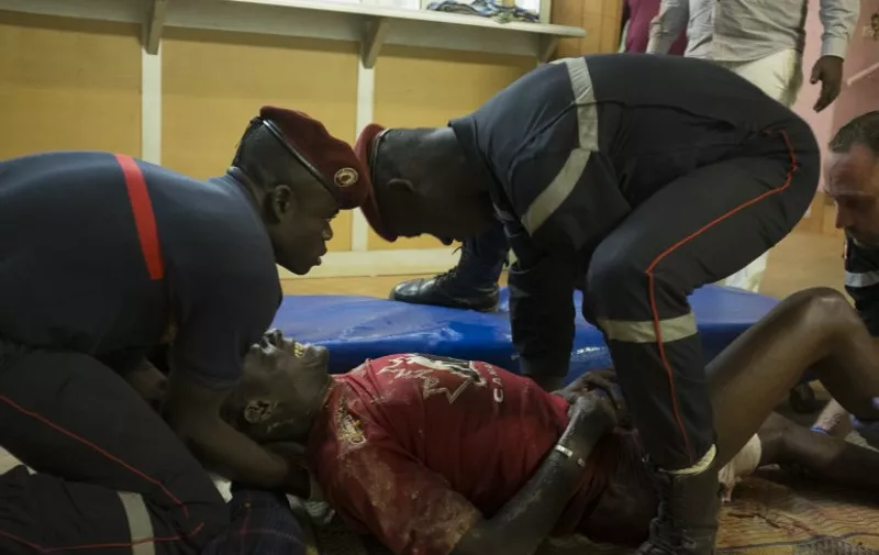 CORRECTION
French first responders tend to wounded people in the surrounding of the hotel Splendide and the café Cappuccino during the attack on January 15, 2016.  Sixty-three hostages, including 33 wounded, were evacuated in the early hours of Saturday from a Burkina Faso hotel besieged by Al-Qaeda-linked gunmen, communication minister Remis Dandjinou told AFP.    AFP PHOTO / NABILA EL HADAD / AFP / NABILA EL HADAD