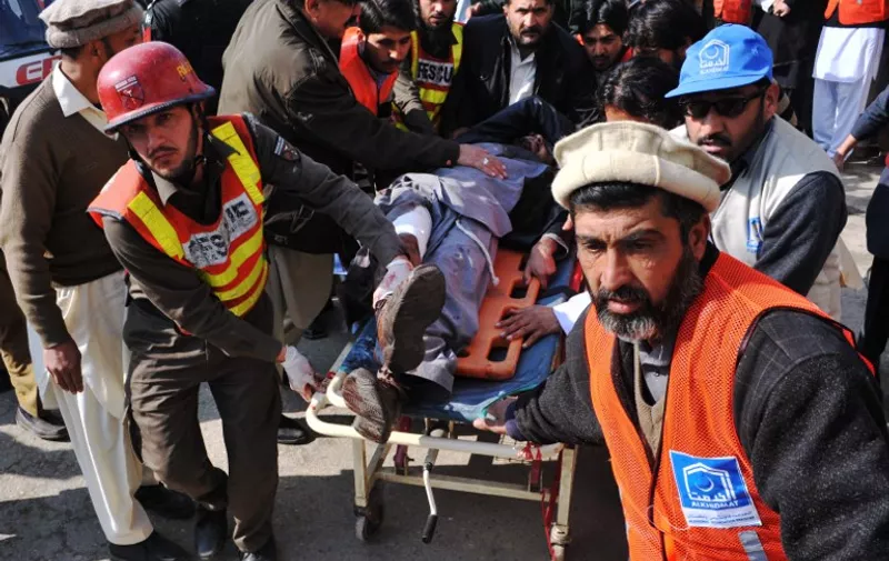 Pakistani rescuers shift an injured man to a hospital following an attack by gunmen in the Bacha Khan university in Charsadda, about 50 kilometres from Peshawar, on January 20, 2016. At least 21 people died in an armed assault on a university in Pakistan on January 20, where witnesses reported two large explosions as security forces moved in under dense fog to halt the bloodshed. AFP PHOTO /Hasham AHMED / AFP / HASHAM AHMED