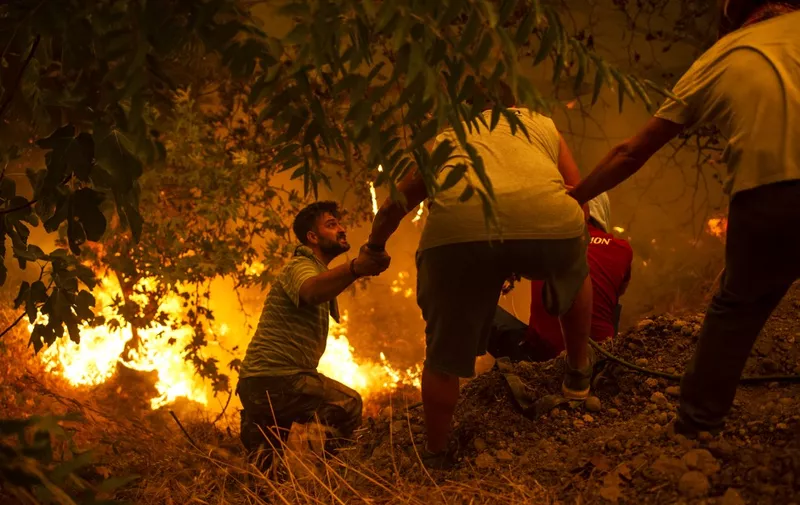 Local residents fight the wildfire in the village of Gouves on Evia (Euboea) island, second largest Greek island, on August 8, 2021. - Hundreds of Greek firefighters fought desperately on August 8 to control wildfires on the island of Evia that have charred vast areas of pine forest, destroyed homes and forced tourists and locals to flee. (Photo by ANGELOS TZORTZINIS / AFP)