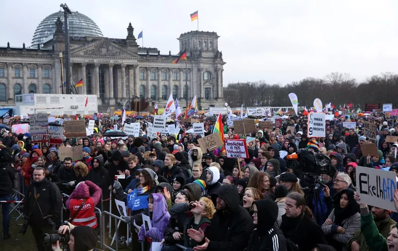 Demonstrators protest against the far-right Alternative for Germany (AfD) party outside the Reichstag building in Berlin, Germany on February 3, 2024, during a rally under the motto 'We are the firewall' called for by international non-profit organisation 'Hand in Hand' to protest against right-wing politics. Thousands of protesters gathered outside the Reichstag building in central Berlin to demonstrate against racism and the far right, with many more peaceful rallies planned across the country. (Photo by Adam BERRY / AFP)
