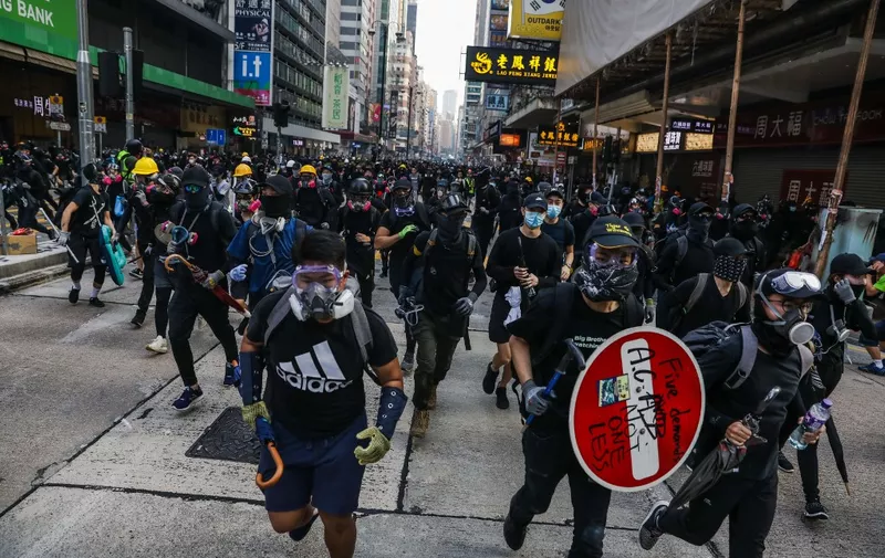 Protesters run from advancing police on a road in the Tsim Sha Tsui district in Hong Kong on October 20, 2019. - Police fired water cannon and tear gas at Hong Kongers who defied authorities with an illegal march on October 20, their numbers swollen by anger over the recent stabbing and beating of two pro-democracy protesters. (Photo by DALE DE LA REY / AFP)