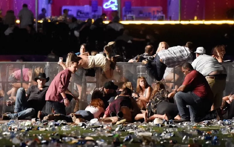 LAS VEGAS, NV - OCTOBER 01: People scramble for shelter at the Route 91 Harvest country music festival after apparent gun fire was heard on October 1, 2017 in Las Vegas, Nevada. A gunman has opened fire on a music festival in Las Vegas, leaving at least 20 people dead and more than 100 injured. Police have confirmed that one suspect has been shot. The investigation is ongoing.   David Becker/Getty Images/AFP