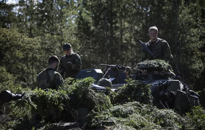 Soldiers of the P18 Gotland Regiment of the Swedish Army camouflage  armoured vehicles during a field exercise near Visby on the Swedish island of Gotland on May 17, 2022. Finland and Sweden are expected to announce this week whether to apply to join NATO following Russia's Ukraine invasion, in what would be a stunning reversal of decades-long non-alignment policies. On Sweden's strategically-located Baltic Sea island of Gotland, Home Guard troops were last week called in for a special month-long training exercise, coinciding with annual military exercises taking place across Finland and Sweden next week. (Photo by Jonathan NACKSTRAND / AFP)