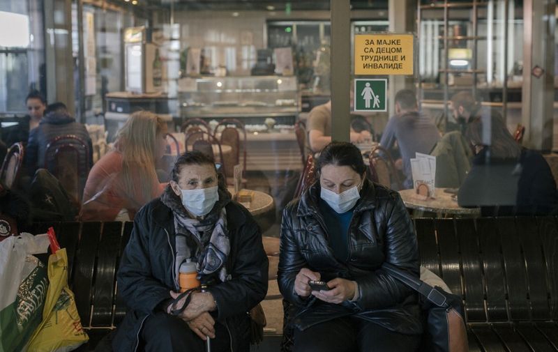 Women wearing face masks as preventive measures against COVID-19 (novel Coronavirus) wait at Belgrade's main bus station on March 16, 2020. - Serbia declared a state of emergency on March 15, 2020 to halt the spread of the new coronavirus, shutting down many public spaces, deploying soldiers to guard hospitals and closing the borders to foreigners. Serbia's President Aleksandar Vucic said the new restrictions were necessary to "save our elderly" in the Balkan state of some seven million, which has detected around 55 infections of COVID-19 so far with limited testing. (Photo by Vladimir Zivojinovic / AFP)