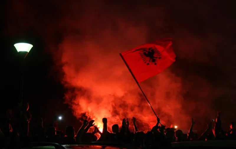 Albanian fans await the arrival of the national soccer team following the abandoned Euro 2016 qualifying match between Albania and Serbia, at Tirana's Mother Teresa airport, early on October 15, 2014. A Euro 2016 qualifying match between Serbia and Albania was abandoned after a drone carrying a pro-Albanian message was flown over the stadium late Tuesday, sparking violent scenes on and off the pitch.  / 