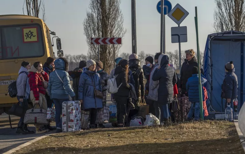 People evacuated from the self-proclaimed Donetsk People's Republic walk toward the Russian Emergency Ministry camp in the village of Veselo-Voznesenka on the Azov Sea coast, on February 19, 2022. - A Russian region bording Ukraine declared a state of emergency on February 19, 2022, citing growing numbers of people arriving from separatist-held regions in Ukraine after they received evacuation orders. (Photo by Andrey BORODULIN / AFP)