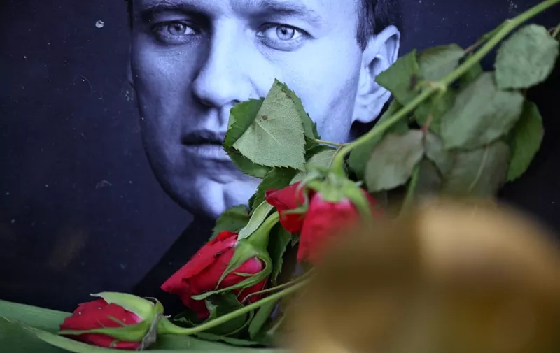 Roses are laid at a picture of late Russian opposition leader Alexei Navalny at a makeshift memorial in Frankfurt am Main, western Germany, on February 29, 2024. Russian opposition leader Alexei Navalny's funeral service will be held at a church in southern Moscow on March 1st 2024, allies of the politician said. "Alexei's funeral will be held in a church ... in Maryino on 1 March at 14:00 (1100 GMT). Come in advance," his team said in a social media post on February 28, 2024. (Photo by AFP)