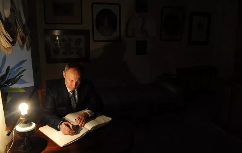 Russian President Vladimir Putin signs a guests' book as he visits Russian writer Leo Tolstoy's main estate museum in Yasnaya Polyana outside Tula on September 8, 2016. / AFP PHOTO / SPUTNIK / Mikhail KLIMENTIEV