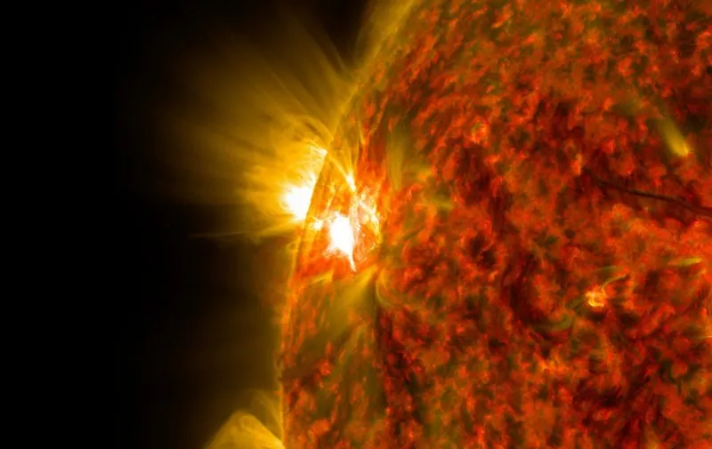 This NASA image obtained November 6, 2014  shows an active region on the sun as it emitted a mid-level solar flare, peaking at 4:47 a.m. EST on November 5, 2014. This is the second mid-level flare from the same active region, labeled AR 12205, which rotated over the left limb of the sun on November 3, 2014. The image was captured by NASA's Solar Dynamics Observatory (SDO) in extreme ultraviolet light that was colorized in red and gold. Solar flares are powerful bursts of radiation. Harmful radiation from a flare cannot pass through Earth's atmosphere to physically affect humans on the ground, however -- when intense enough -- they can disturb the atmosphere in the layer where GPS and communications signals travel. This flare is classified as an M7.9-class flare. M-class flares are a tenth the size of the most intense flares, the X-class flares. The number provides more information about its strength. An M2 is twice as intense as an M1, an M3 is three times as intense, etc. AFP PHOTO/NASA/SDO/HANDOUT =  RESTRICTED TO EDITORIAL USE / MANDATORY CREDIT: "AFP PHOTO HANDOUT-NASA/SDO"/ NO MARKETING - NO ADVERTISING CAMPAIGNS/  NO A LA CARTE SALES / DISTRIBUTED AS A SERVICE TO CLIENTS /  =