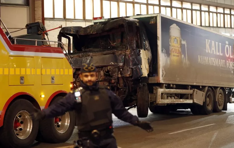 The stolen truck, which was driven through a crowd outside a department in Stockholm on April 7, 2017, is taken away on April 8.
A massive manhunt was underway for the driver of the stolen truck that ploughed into the crowd, killing four and injuring 15, Swedish police said. National police chief, Stefan Hector, said the police's "working hypothesis is that this is a terror attack." / AFP PHOTO / Odd ANDERSEN
