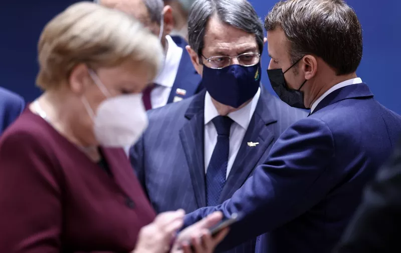 (fromR) France's President Emmanuel Macron, Cyprus' President of the Republic Nicos Anastasiades and Germany's Chancellor Angela Merkel, wearing face masks, attend a face-to-face meeting on the second day of a two days EU summit, in Brussels, on October 16, 2020. (Photo by KENZO TRIBOUILLARD / POOL / AFP)