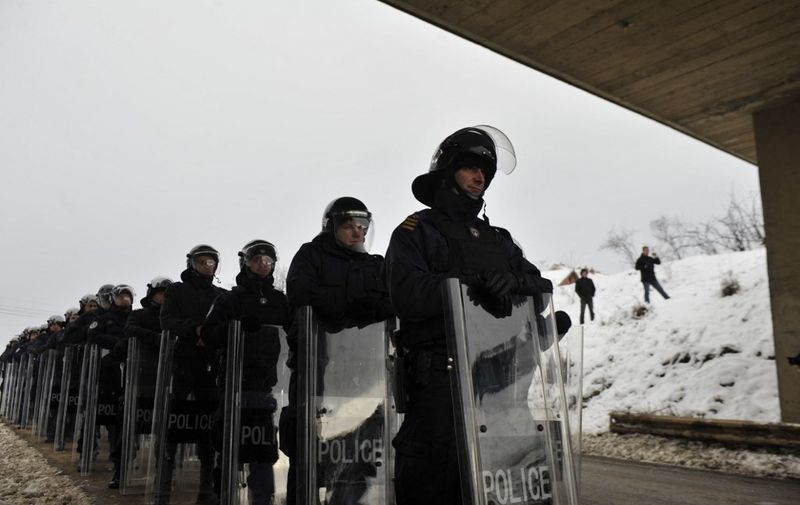 Kosovo riot police face hardline ethnic Albanian protesters of the nationalist Self-Determination Movement on January 22, 2012 near Podujevo, a town in northern Kosovo some six kms (four miles) from the main Merdare crossing to Serbia. Kosovo police and the protesters were locked in a tense stand-off as the authorities stopped some 1,000 demonstrators from blocking a border crossing with Serbia. Police in anti-riot gear prevented the protesters from moving beyond Podujevo.    
AFP PHOTO / ARMEND NIMANI (Photo by ARMEND NIMANI / AFP)
