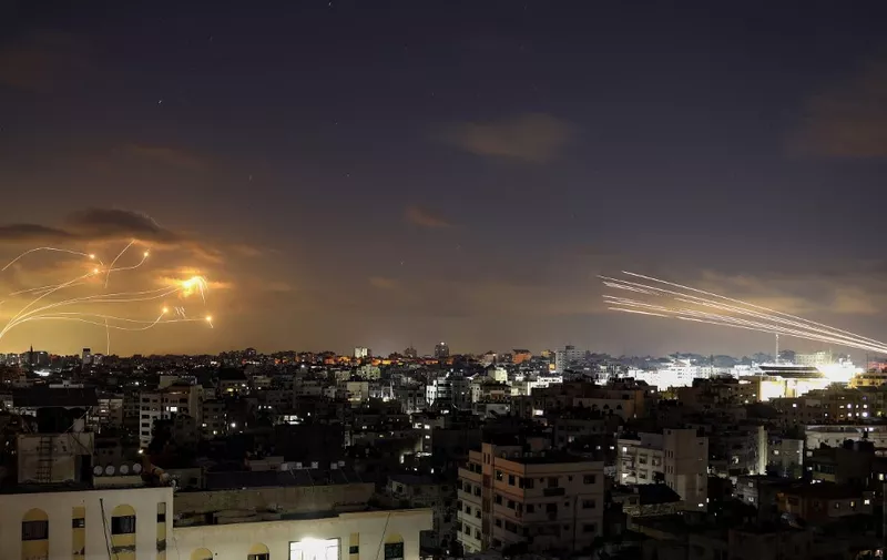 A picture shows rockets fired from the Gaza City (R) being intercepted by Israel's Iron Dome defence missile system (L) on October 10, 2023. Israel said it recaptured Gaza border areas from Hamas as the war's death toll passed 3,000 on October 10, the fourth day of gruelling fighting since the Islamists launched a surprise attack. (Photo by Eyad BABA / AFP)