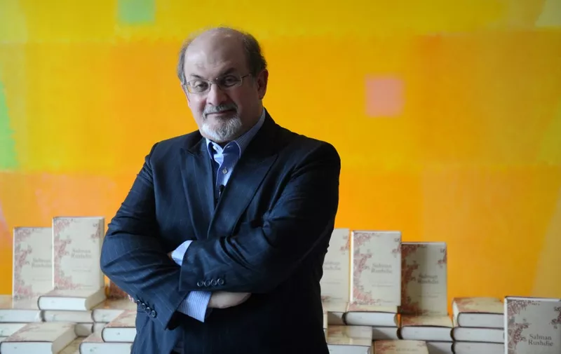 British author Salman Rushdie poses in front of some copies of his book "Joseph Anton" on October 1, 2012 in Berlin. As violent protests over a US-made film rock the Muslim world, Salman Rushdie publishes his account of the decade he spent in hiding while under a fatwa for his book "The Satanic Verses".     AFP PHOTO / JOHANNES EISELE (Photo by JOHANNES EISELE / AFP)