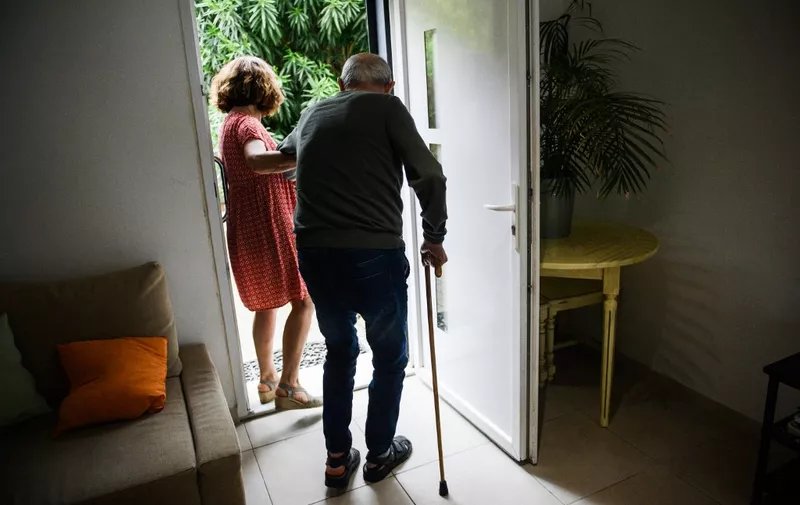 Caregiver Nadia Chebil (L) helps Andre-Pierre (R) at "Les Papillons de Marcelle" house, in Arles, southeastern France, on May 9, 2023. In France, about 4,750 senior citizens live with a foster carer, a drop in the bucket compared to the 600,000 or so residents in Ehpad. (Photo by CLEMENT MAHOUDEAU / AFP)