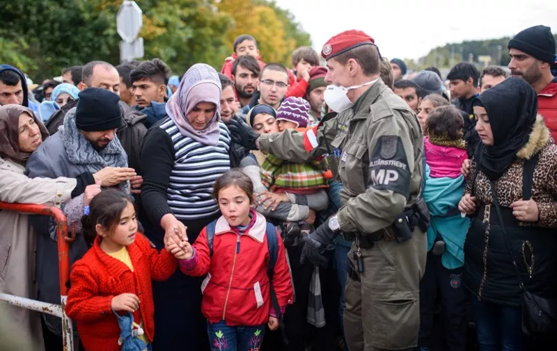 Migrants and refugees cross the Slovenian-Austrian border in Sentilj onto Spielfeld on October 20, 2015. Slovenia called in the army to help manage a surge of asylum seekers desperately trying to reach northern Europe ahead of winter, as the tiny European Union state became the latest hotspot on the migrant trail. AFP PHOTO / JURE MAKOVEC
