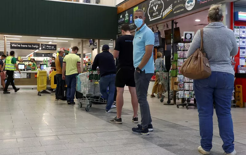 Residents queue up outside a shopping centre in eastern Brisbane on July 31, 2021, as Australia's third-largest city Brisbane and other parts of Queensland state will enter a snap Covid-19 lockdown. (Photo by Patrick HAMILTON / AFP)
