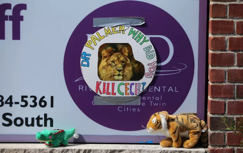 BLOOMINGTON, MN - JULY 29: Protesters place stuffed animals on the sign of Dr. Walter Palmer's River Bluff Dental Clinic to call attention to the alleged poaching of Cecil the lion on July 29, 2015 in Bloomington, Minnesota. According to reports, the 13-year-old lion was lured out of a national park in Zimbabwe and killed by Dr. Palmer, who had paid at least $50,000 for the hunt.   Adam Bettcher/Getty Images/AFP