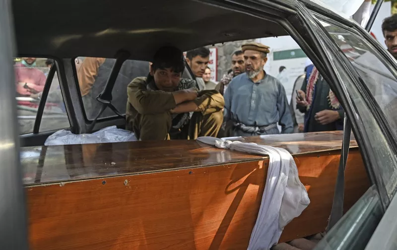 A relative mourns inside a car next to the coffin of a victim of the August 26 twin suicide bombs, which killed scores of people including 13 US troops outside Kabul airport, at a hospital run by the Italian NGO Emergency in Kabul on August 27, 2021. (Photo by Aamir QURESHI / AFP)