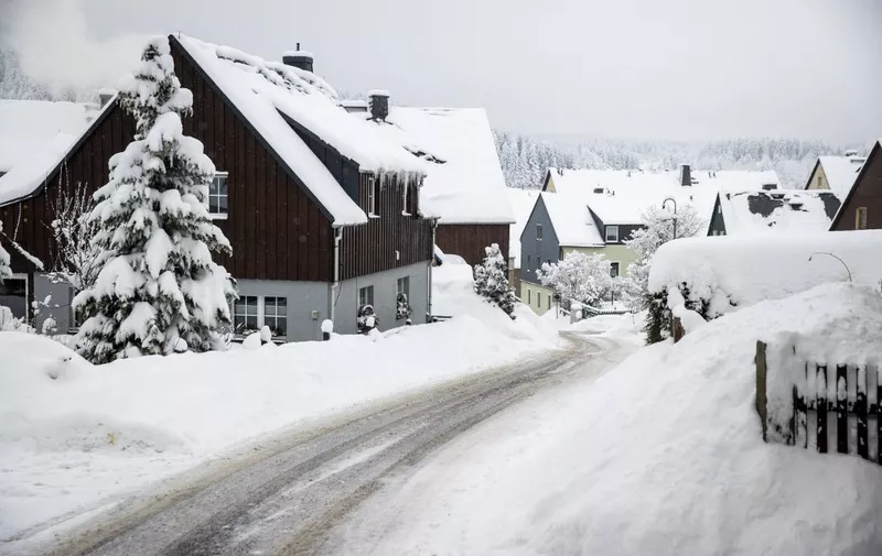 Snow covered streets are seen in the village of Altenberg, eastern Germany on, February 10, 2021. - Snowfall, heavy gusts of wind and sub-zero temperatures in north and western Germany have caused interruptions of travel. (Photo by Odd ANDERSEN / AFP)