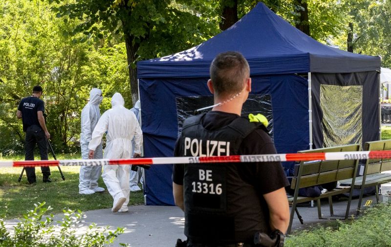 (FILES) This file photo taken on August 23, 2019 (FILES) shows forensic experts of the police securing evidences at the site of a crime scene in a park of Berlin's Moabit district, where a man of Georgian origin was shot dead. - A Russian national, identified by media as Vadim Krasikov and suspected of carrying out a state-sponsored contract killing, will go on trial in October, a court said September 2, 2020, amid an escalating diplomatic row. (Photo by Christoph Soeder / dpa / AFP) / Germany OUT